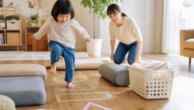 家庭でクッション遊びを楽しむ親子